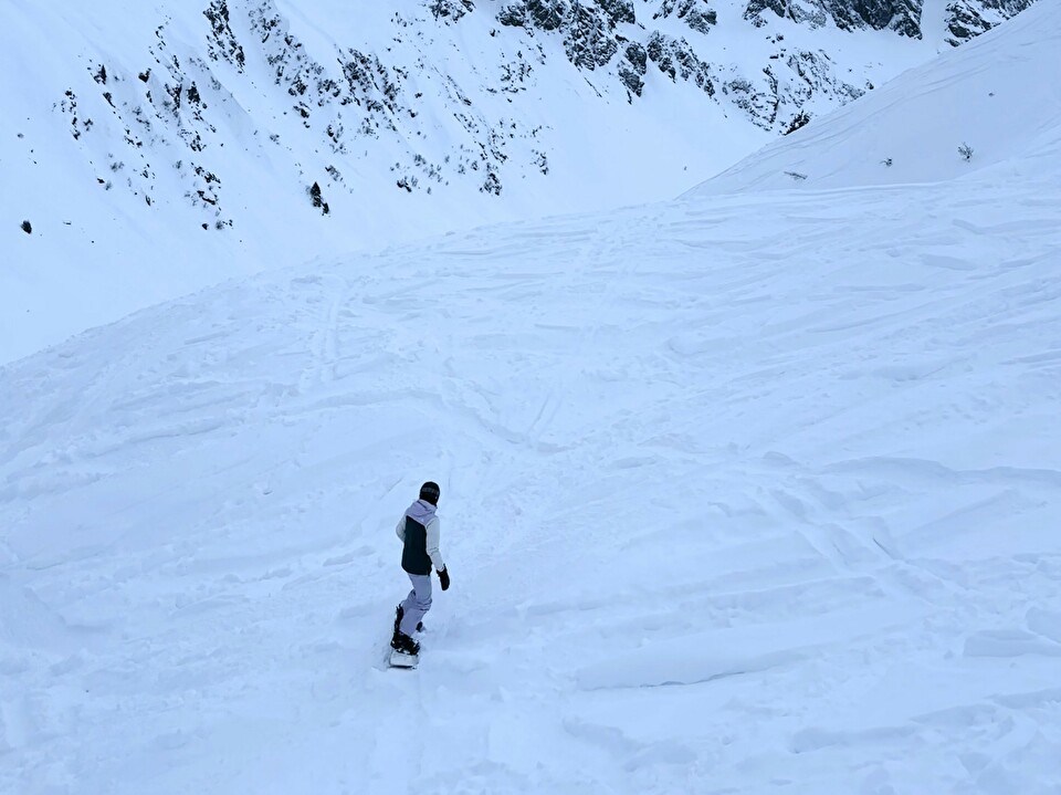 View of the mountains and a person snowboarding